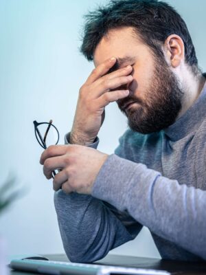 tired-man-rubs-his-eyes-front-computer-screen (1)